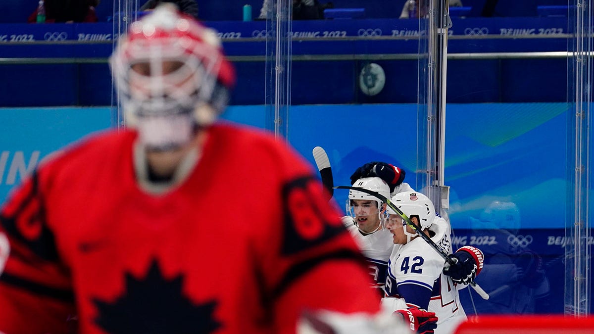 United States players Aaron Ness (42) and Kenny Agostino (11) celebrate after teammate Andy Miele scored a goal against Canada goalkeeper Eddie Pasquale, left, during a preliminary round men's hockey game at the 2022 Winter Olympics, Saturday, Feb. 12, 2022, in Beijing.