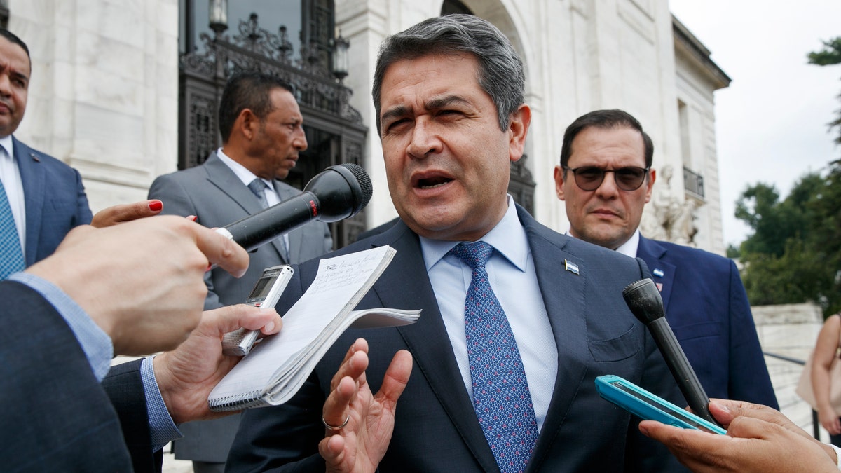 Honduran President Juan Orlando Hernandez answers questions from the Associated Press, Tuesday, Aug. 13, 2019, as he leaves a meeting at the Organization of American States, in Washington. 
