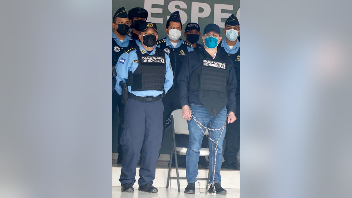 Former Honduran President Juan Orlando Hernandez, in chains, is shown to the press at the Police Headquarters in Tegucigalpa, Honduras, Tuesday, Feb. 15, 2022. 