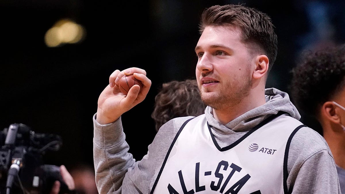 Dallas Mavericks forward Luka Doncic sets to throw a souvenir to fans during a practice session for the NBA All-Star basketball game in Cleveland, Saturday, Feb. 19, 2022.