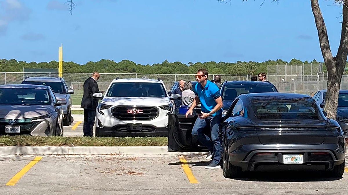New York Mets pitcher Max Scherzer gets out of his car as he arrives for baseball labor talks at Roger Dean Stadium in Jupiter, Fla., Wednesday, Feb. 23, 2022. At far left is Major League Baseball Players Association executive director Tony Clark.