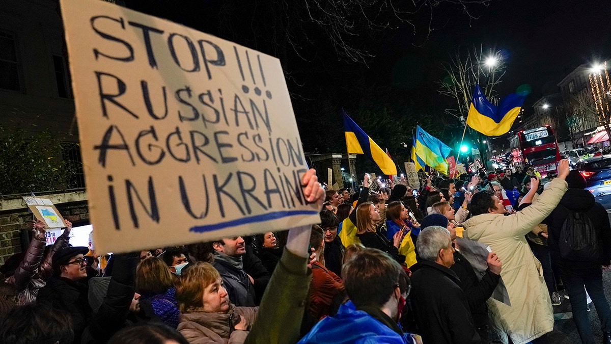 Demonstrators hold placards and flags as they attend a protest outside the Russian Embassy, in London, Wednesday, Feb. 23, 2022. Ukraine urged its citizens to leave Russia as Europe braced for further confrontation Wednesday after Russia's leader received authorization to use military force outside his country and the West responded with a raft of sanctions. 