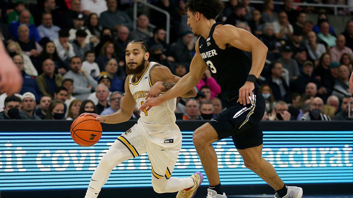 Providence's Jared Bynum (4) is defended by Xavier's Colby Jones (3) during the first half of an NCAA college basketball game Wednesday, Feb. 23, 2022, in Providence, R.I. 