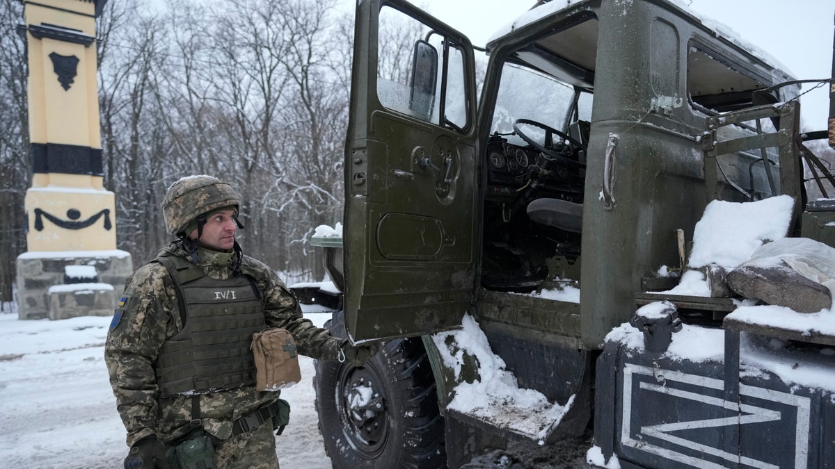 A Ukrainian serviceman opens the door of a deactivated Russian military multiple rocket launcher on the outskirts of Kharkiv, Ukraine, on Friday, Feb. 25, 2022. Russian troops bore down on Ukraine's capital Friday, with gunfire and explosions resonating ever closer to the government quarter, in an invasion of a democratic country that has fueled fears of wider war in Europe and triggered worldwide efforts to make Russia stop.