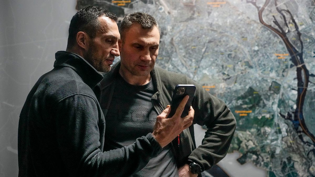 Vitali Klitschko, Kyiv Mayor and former heavyweight champion, right, and his brother Wladimir Klitschko, a Ukrainian former professional boxer look at a smart phone in the City Hall in Kyiv, Ukraine, Sunday, Feb. 27, 2022. A Ukrainian official says street fighting has broken out in Ukraine's second-largest city of Kharkiv. Russian troops also put increasing pressure on strategic ports in the country's south following a wave of attacks on airfields and fuel facilities elsewhere that appeared to mark a new phase of Russia's invasion.