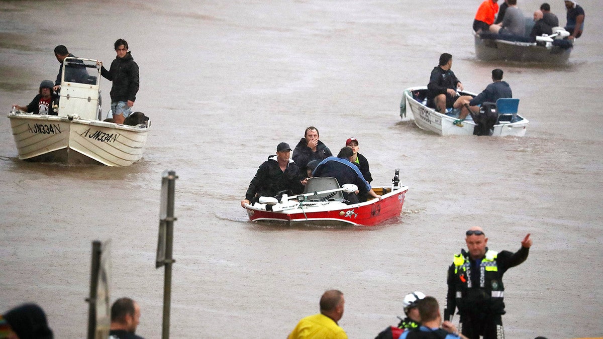 People use small boats to travel through flood water in Lismore, Australia, Monday, Feb. 28, 2022.
