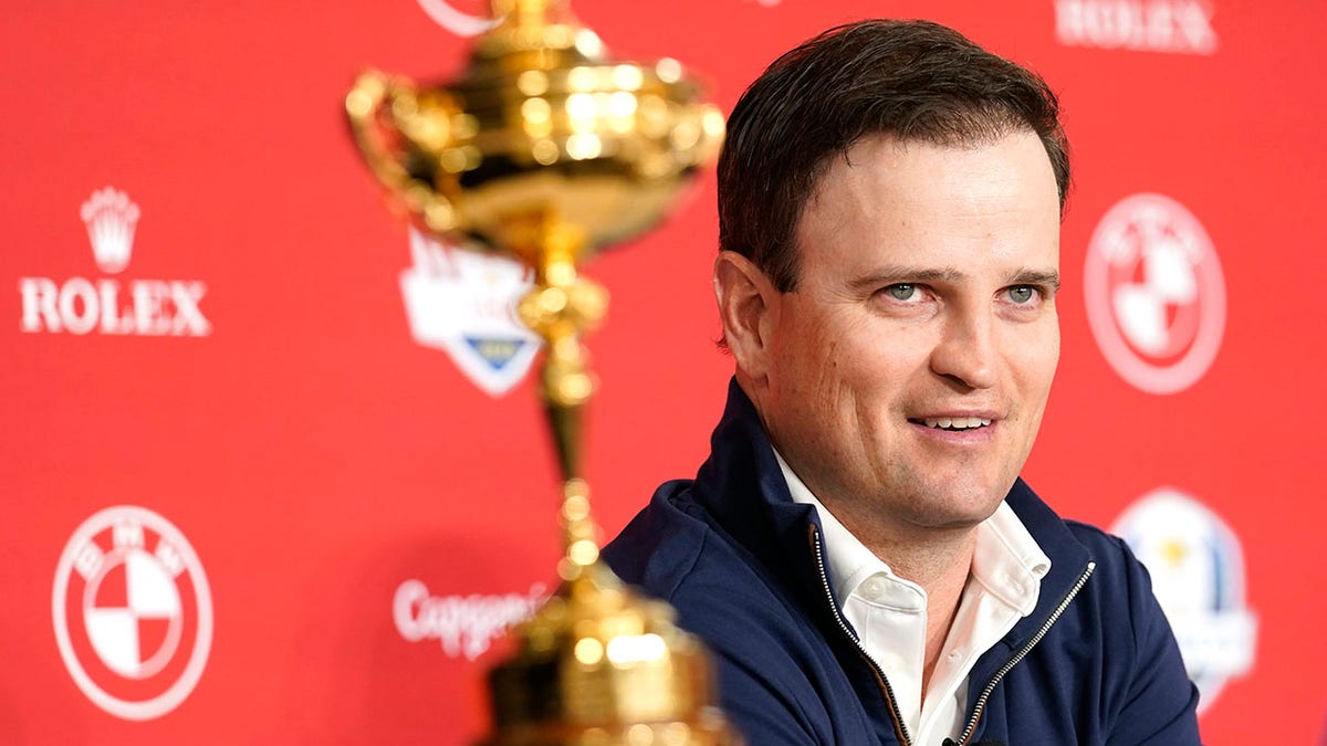 Zach Johnson sits next to the Ryder Cup trophy after being named the 2023 United States Ryder Cup golf captain at PGA of America headquarters, Monday, Feb. 28, 2022, in Palm Beach Gardens, Fla.