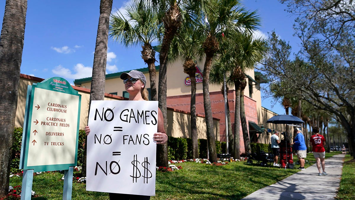 Detroit Tigers fan Genna Perugini of Melbourne, Fla. holds a sign outside of Roger Dean Stadium where negotiations between Major League Baseball and the players union continue in an attempt to reach an agreement to salvage March 31 openers and a 162-game season, Monday, Feb. 28, 2022, in Jupiter, Fla.