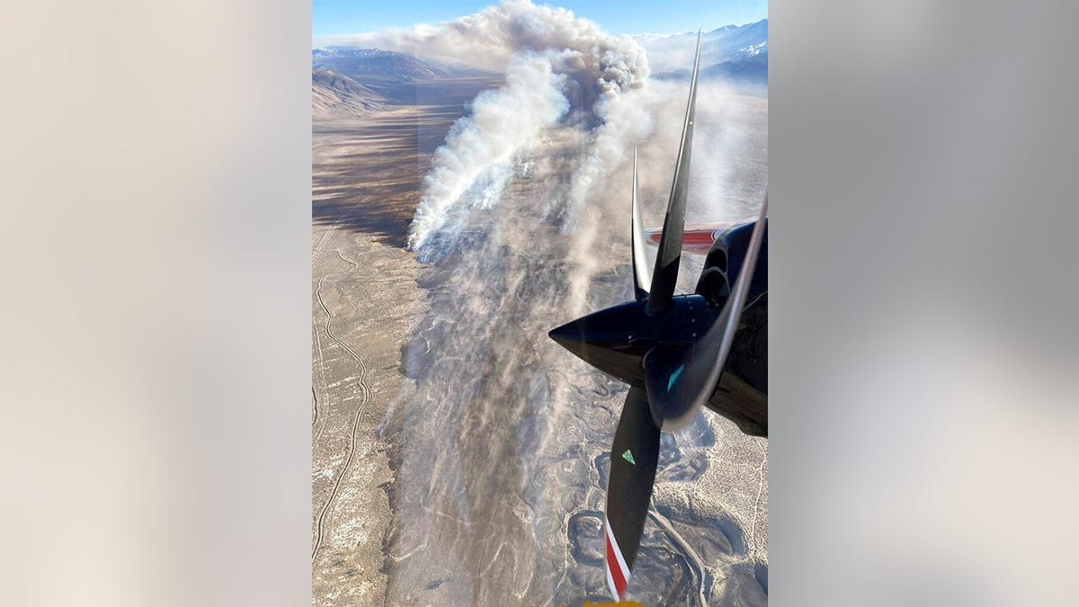 This photo provided by CAL FIRE San Bernardino Unit Public Information Office shows smoke from a blaze that erupted Wednesday, Feb. 16, 2022, near Eastern Sierra Regional Airport just outside the town of Bishop, Calif.
