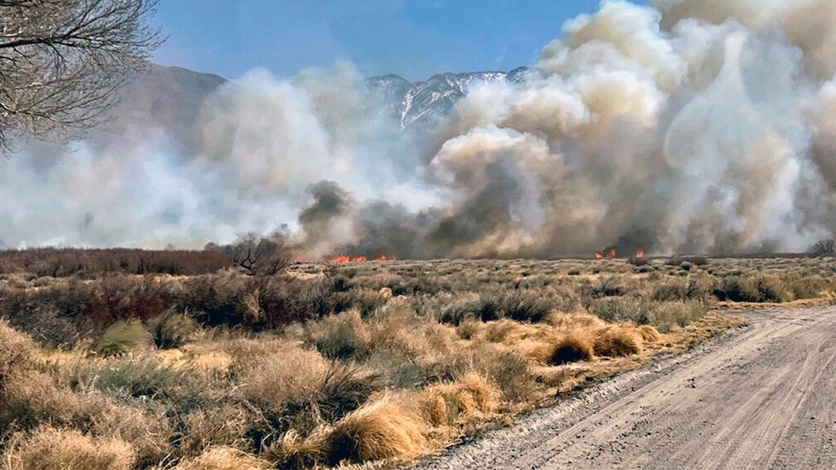 This photo provided by CAL FIRE San Bernardino Unit Public Information Office shows smoke and fire from a wildfire near in Owens Valley, Calif. on Thursday, Feb. 17, 2022. 