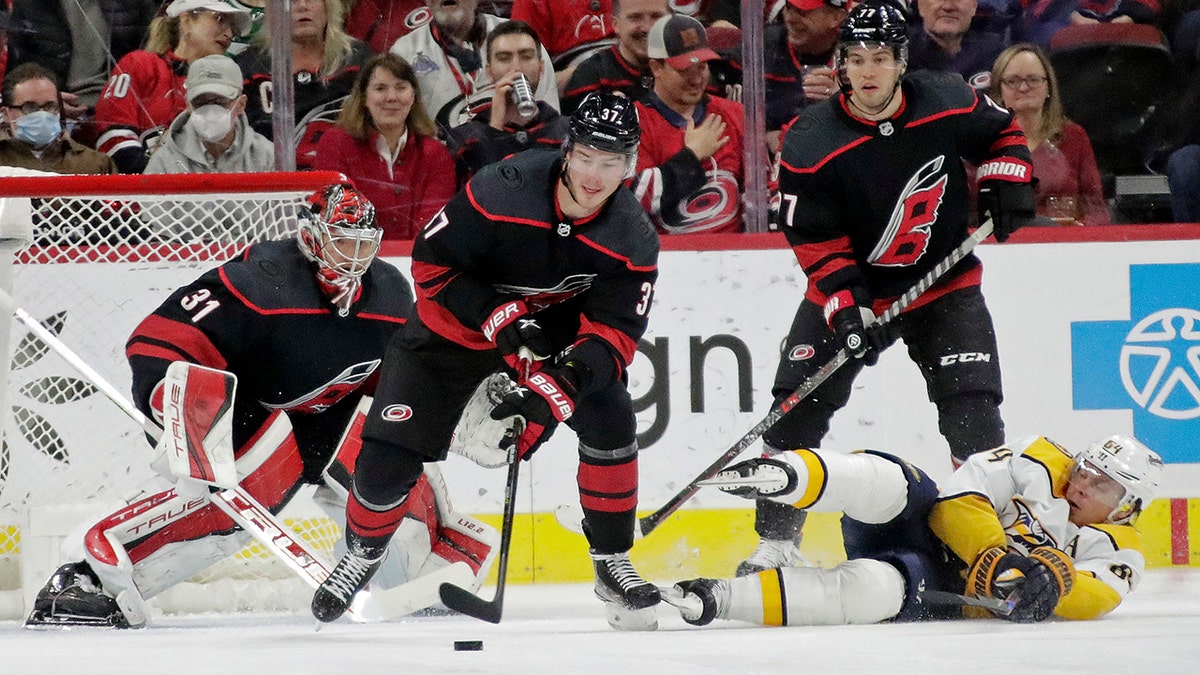 Carolina Hurricanes right wing Andrei Svechnikov (37) controls the puck in front of goaltender Frederik Andersen (31) and defenseman Tony DeAngelo, top right, next to fallen Nashville Predators center Mikael Granlund during the second period of an NHL hockey game Friday, Feb. 18, 2022, in Raleigh, N.C.