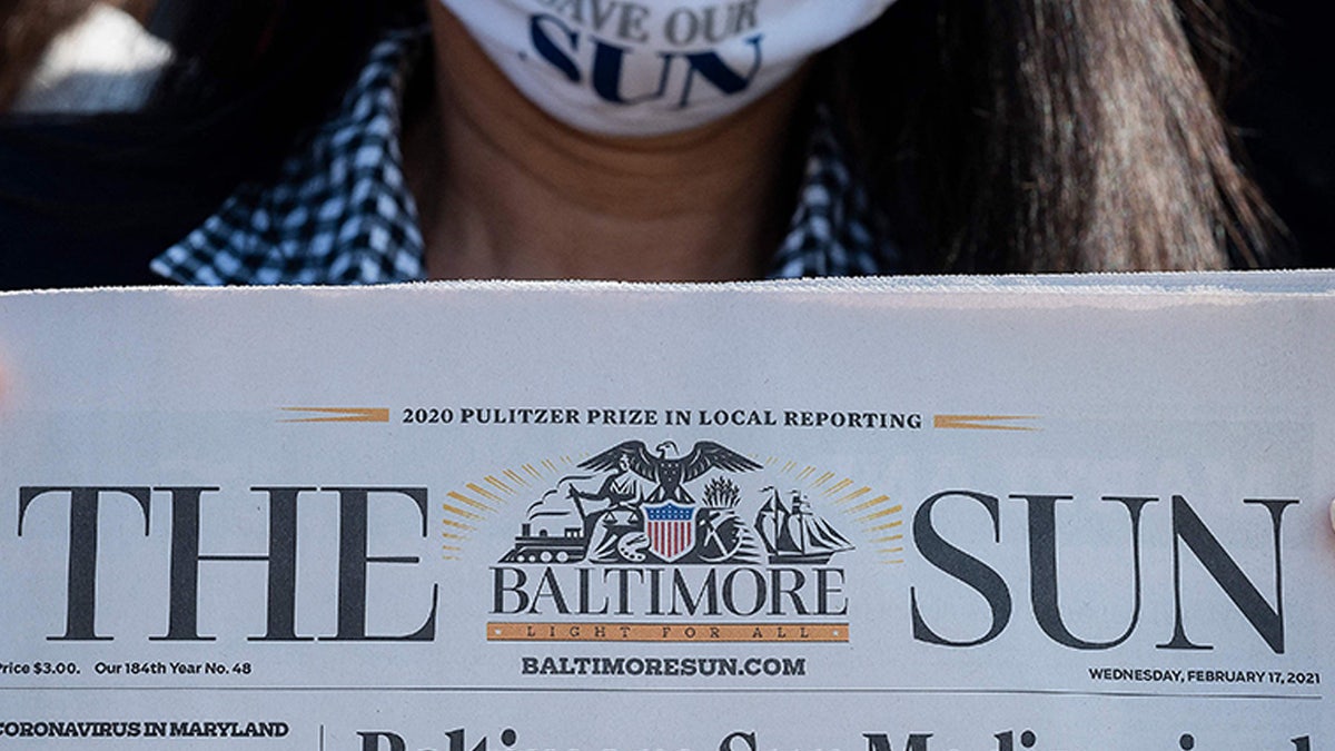 Baltimore Sun reporter Jean Marbella holds up the Baltimore Sun front page that headlined their potential take over by a nonprofit group during an interview in Baltimore, Maryland on March 11, 2021. (Photo by JIM WATSON / AFP) (Photo by JIM WATSON/AFP via Getty Images)