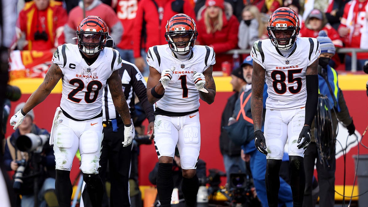Wide receiver Ja'Marr Chase (1) of the Cincinnati Bengals celebrates with running back Joe Mixon (28) and wide receiver Tee Higgins (85) after catching a third-quarter touchdown pass against the Kansas City Chiefs in the AFC Championship Game at Arrowhead Stadium on Jan. 30, 2022, in Kansas City, Missouri.