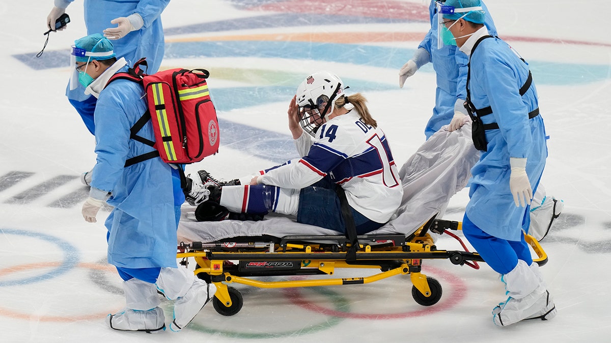 The United States' Brianna Decker is taken off the ice after being injured during a preliminary round women's hockey game against Finland at the 2022 Winter Olympics, Thursday, Feb. 3, 2022, in Beijing.