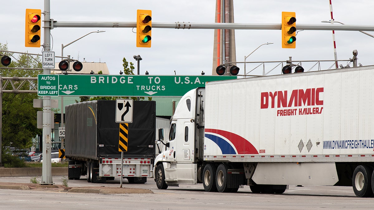Transport trucks pass under a "Bridge To USA" at the entrance to the Ambassador Bridge, US-Canada border crossing. (Windsor, ON)
