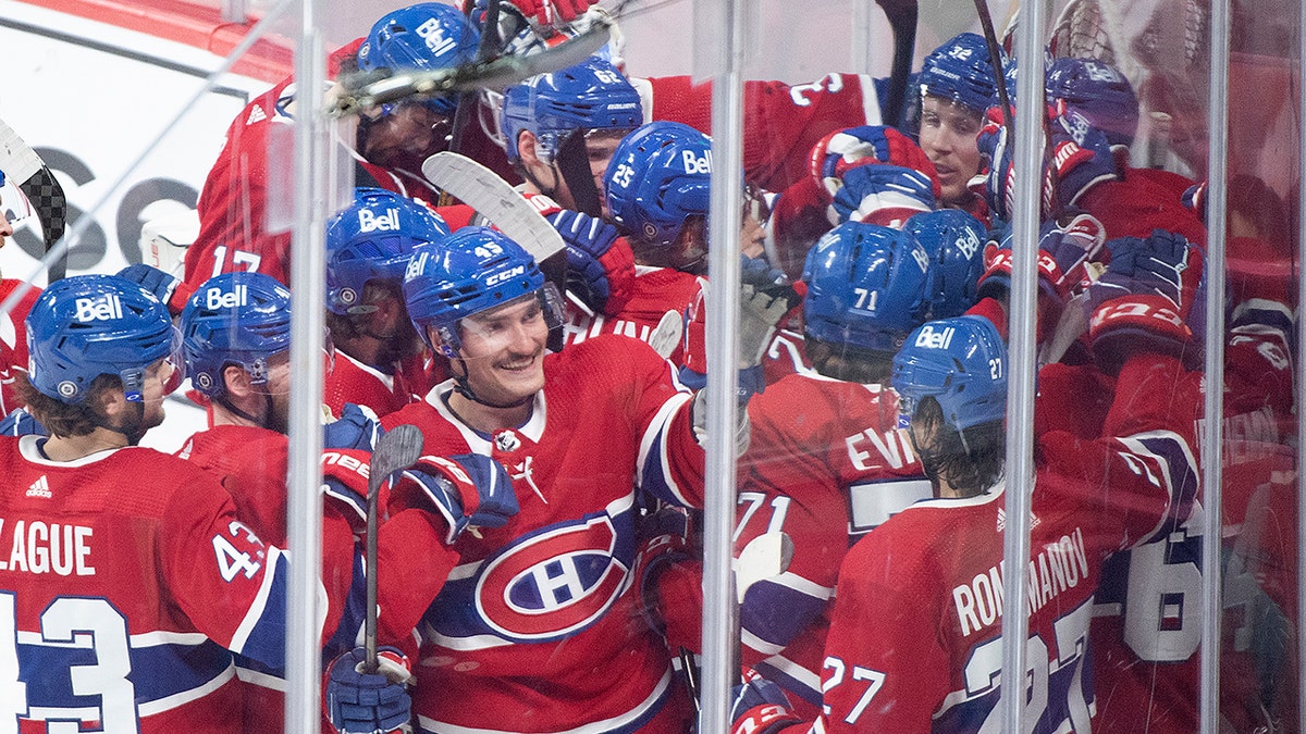 Players from the Montreal Canadiens celebrate a goal by teammate Cole Caufield (22) against the St. Louis Blues during overtime period NHL hockey game action in Montreal, Thursday, Feb. 17, 2022.