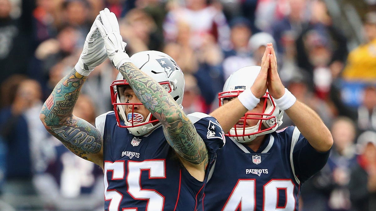Cassius Marsh #55 and Trevor Reilly #49 of the New England Patriots signal for a safety during the second quarter of a game against the Los Angeles Chargers at Gillette Stadium on Oct. 29, 2017, in Foxboro, Massachusetts.