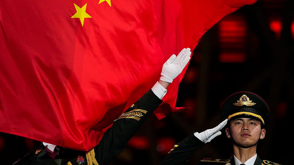 A Chinese flag is raised during a medal ceremony for the women's freestyle skiing big air at the 2022 Winter Olympics