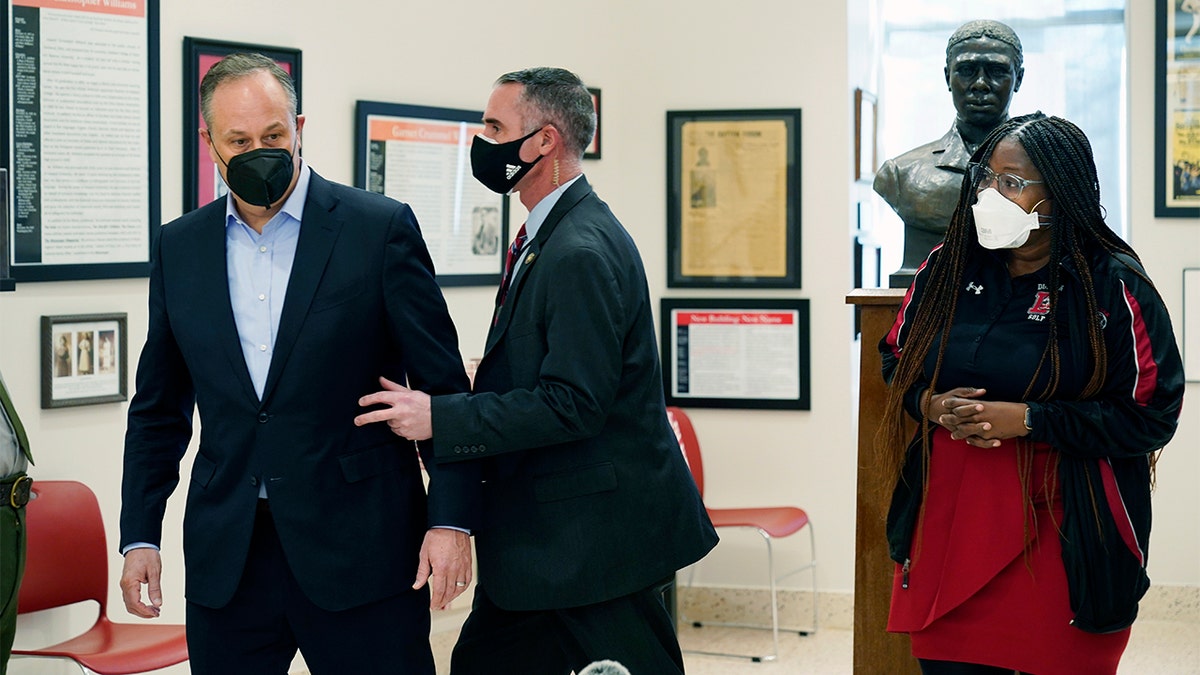 Doug Emhoff, the husband of Vice President Kamala Harris, is whisked out of an event at a high school by a Secret Service agent following an apparent security concern, Tuesday, Feb. 8, 2022 in Washington, D.C. On the far right is Nadine Smith, Dunbar High School principal. (AP Photo/Manuel Balce Ceneta)