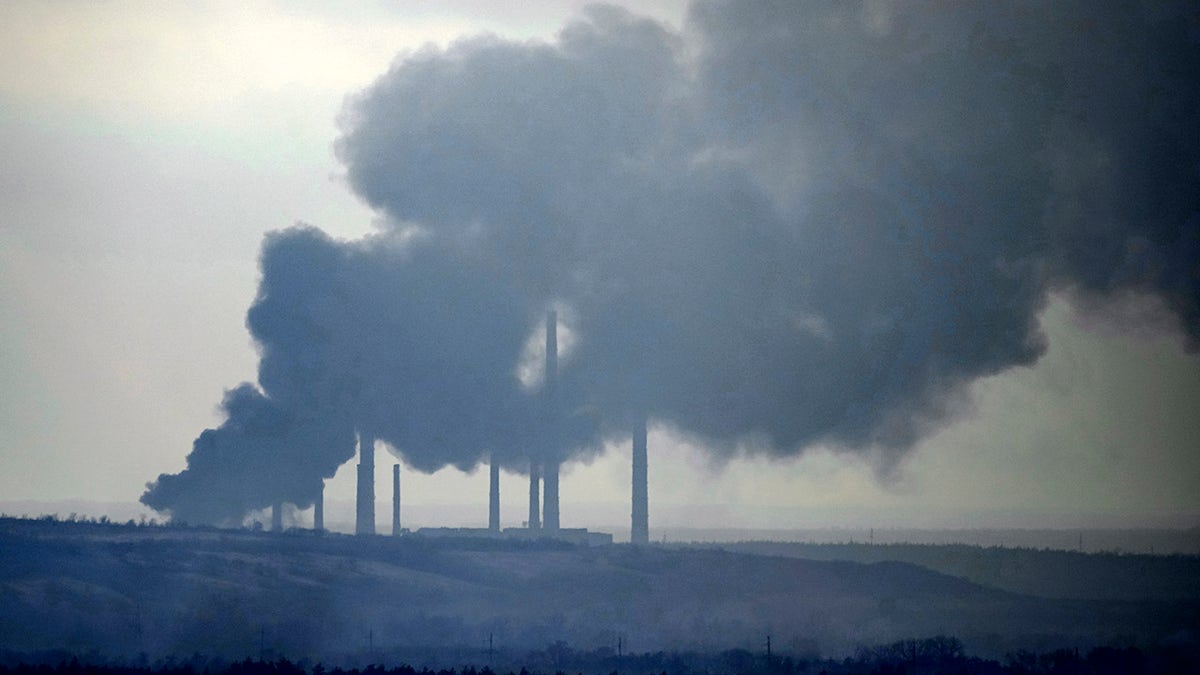 Smoke billows from a power and heating plant after it was shelled in Shchastya, in the Luhansk region, eastern Ukraine, Tuesday, Feb. 22, 2022. 