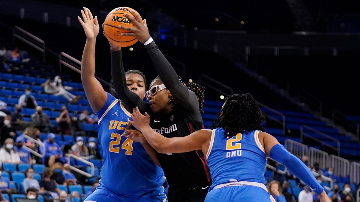 Stanford forward Francesca Belibi, center, drives to the basket between UCLA forward IImar'I Thomas (24) and guard Dominique Onu (2) during the second half of an NCAA college basketball game Thursday, Feb. 3, 2022, in Los Angeles.