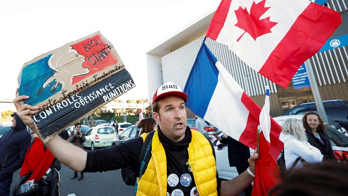 A French activist holds a poster reading "Resistance" before the start of their "Convoi de la liberte" (The Freedom Convoy)