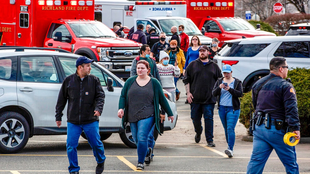 Customers and employees are guided out of a Fred Meyer grocery store after a fatal shooting at the business on Wellsian Way in Richland, Wash., Monday, Feb. 7, 2022.