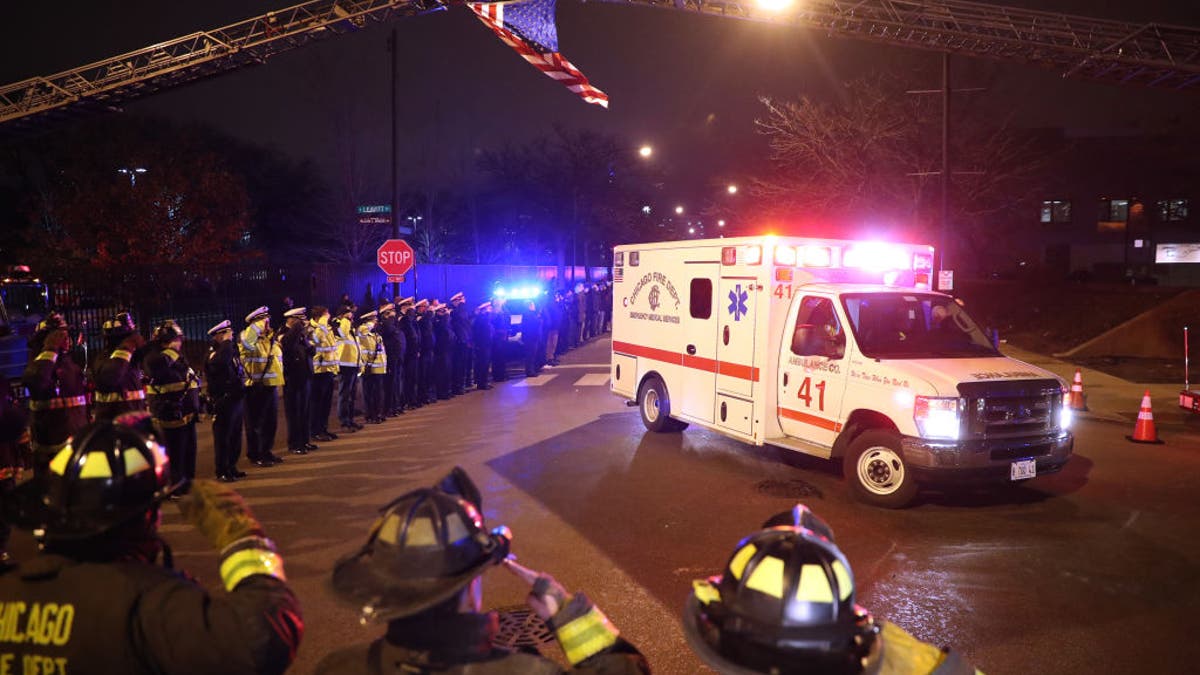 Chicago firefighters and police salute the ambulance carrying the body of Officer Samuel Jimenez outside of the Medical Examiners office at Leavitt and West Harrison streets in Chicago on Nov. 19, 2018.