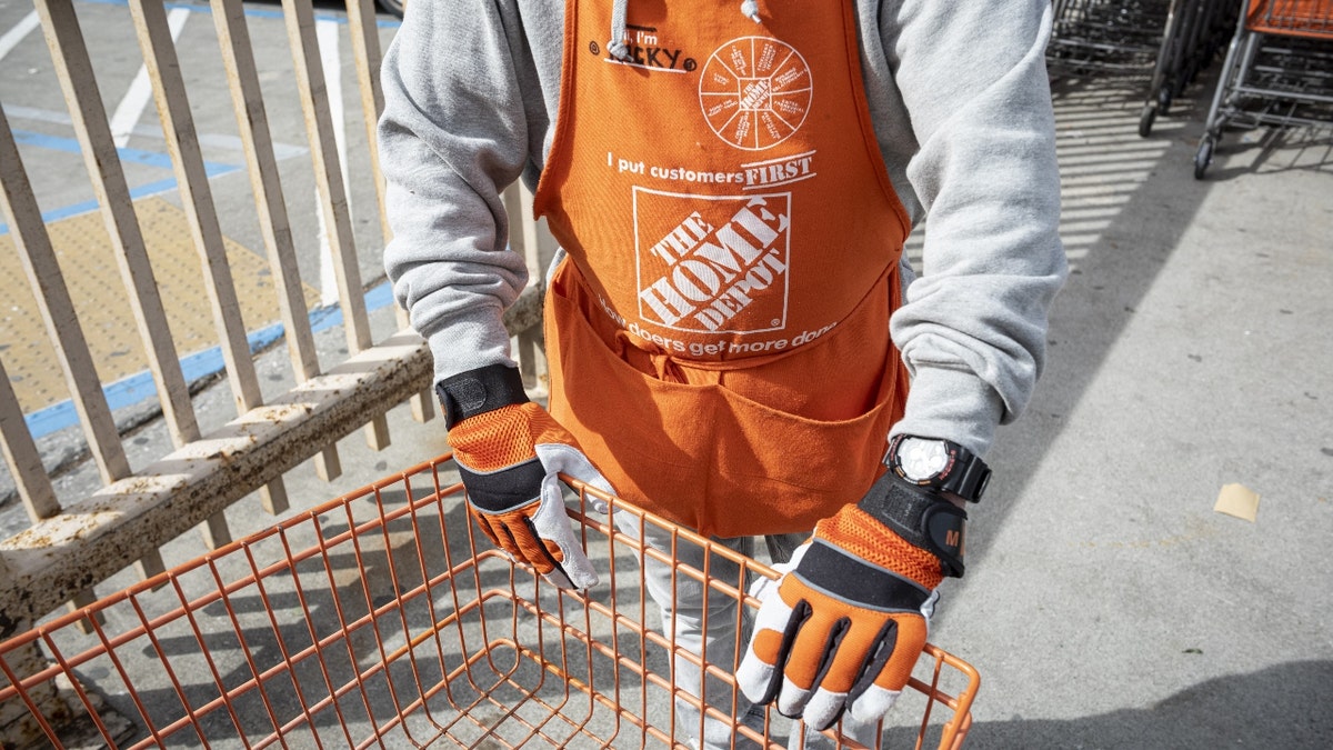 A worker wearing a Home Depot branded apron pushes a shopping cart at a store in Colma, California, U.S., on Thursday, Feb. 18, 2021. Home Depot Inc. is expected to release earnings figures on February 23. Photographer: David Paul Morris/Bloomberg