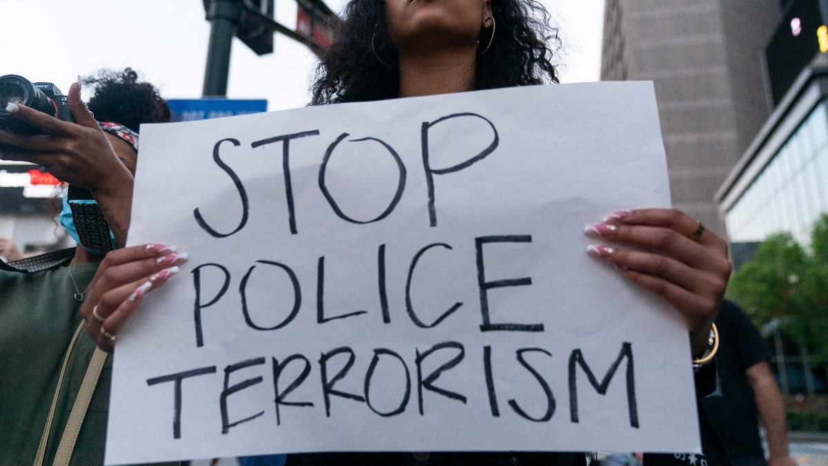 Qri Montague holds a sign while marching following the guilty verdict the trial of Derek Chauvin on April 20, 2021, in Atlanta, Georgia.(Photo by ELIJAH NOUVELAGE/AFP via Getty Images)