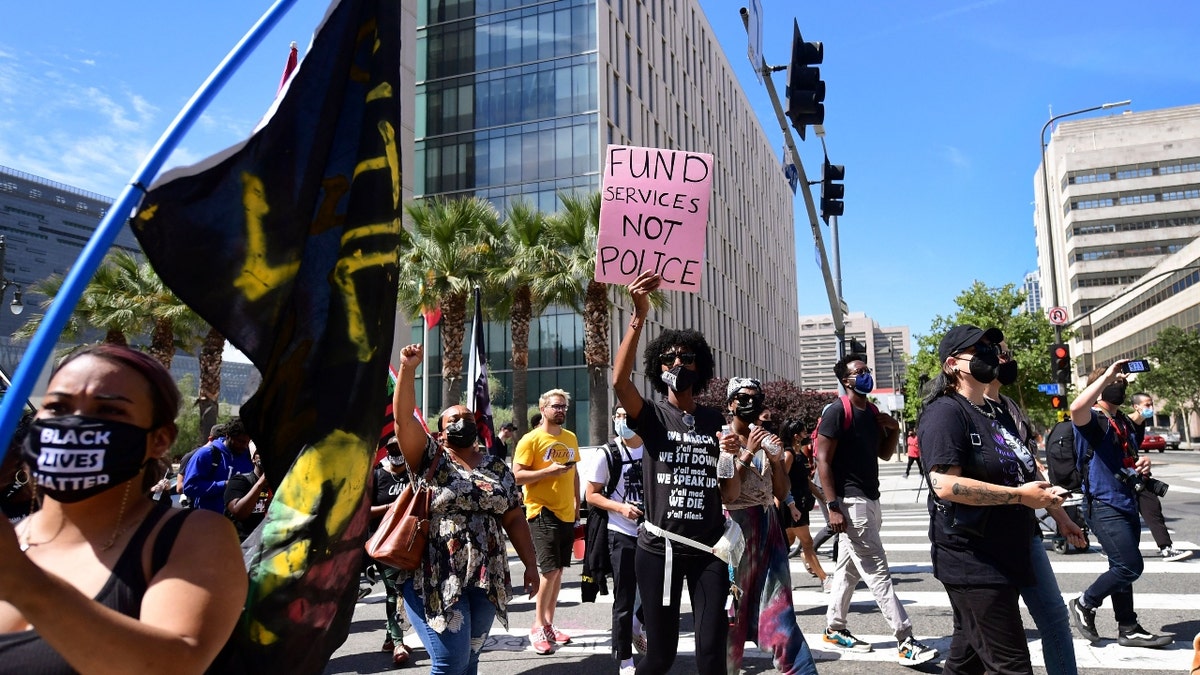 Activists and supporters of Black Lives Matter, march on the one-year anniversary of George Floyd's death on May 25, 2021 in Los Angeles, California. - The "Stay in the Streets" rally was held in honour of George Floyd which began in front of City Hall and across from the Los Angeles Police Department Headquarters. Shortly ahead of a private White House meeting with President Joe Biden, Floyd's relatives and their lawyer spoke to top lawmakers hoping for progress on delayed legislation named after Floyd, who suffocated under the knee of Minneapolis officer Derek Chauvin. (Photo by Frederic J. BROWN / AFP) (Photo by FREDERIC J. BROWN/AFP via Getty Images)
