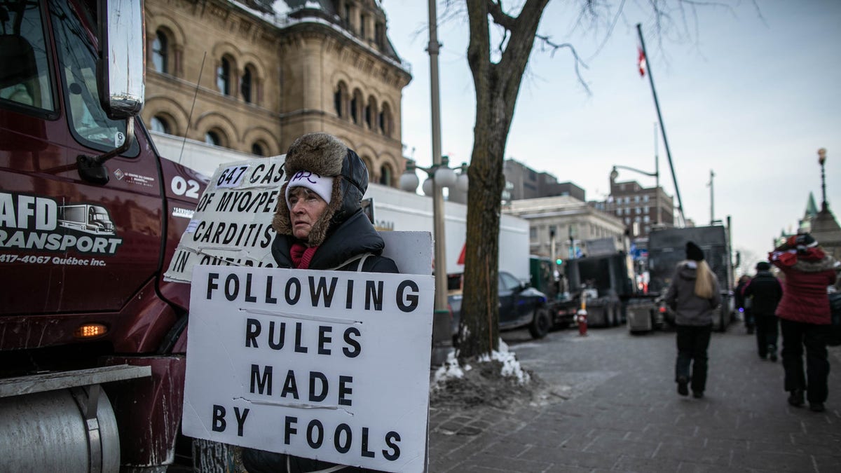 OTTAWA, CANADA, Feb 1, 2022: A protester walk by trucks in front of the Parliament Hill as thousands of truck drivers and supporters protest against vaccine mandates. (Photo by Amru Salahuddien/Anadolu Agency via Getty Images)