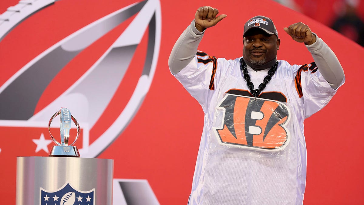 Former Cincinnati Bengals player Ickey Woods celebrates next to the AFC Championship Trophy after the Bengals beat the Kansas City Chiefs Jan. 30, 2022, at Arrowhead Stadium in Kansas City, Missouri.