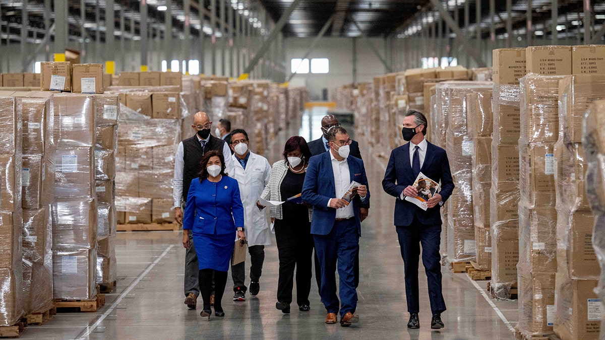 Gov. Gavin Newsom, right, walks through rows of boxed PPE with dignitaries and elected officials, as he prepares to announce the next phase of Californias COVID-19 response called SMARTER, during a press conference at the UPS Healthcare warehouse in Fontana on Thursday, Feb. 17, 2022. ?(Photo by Watchara Phomicinda/MediaNews Group/The Press-Enterprise via Getty Images)