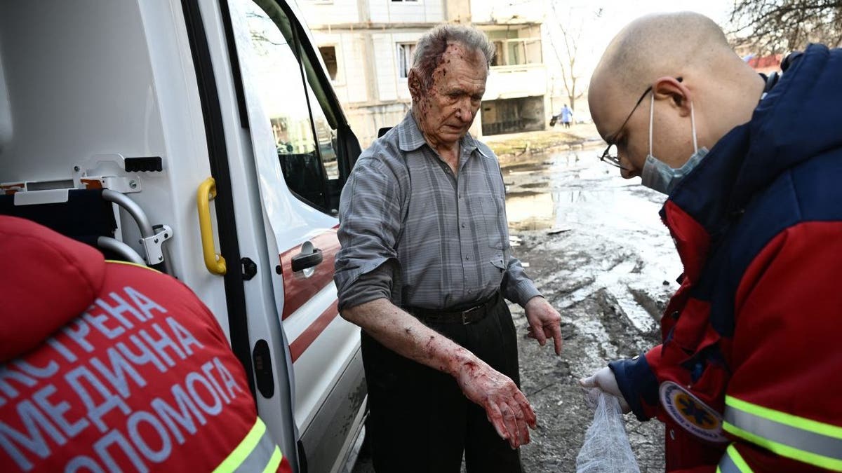 Emergency unit staff treat an injured man after bombings on the eastern Ukraine town of Chuguiv on February 24, 2022,