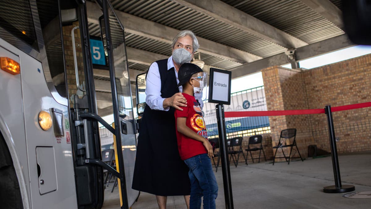 BROWNSVILLE, TEXAS - FEBRUARY 26: Sister Norma Pimentel, Executive Director of Catholic Charities of the Rio Grande Valley escorts a young asylum seeker upon his entry into the United States on February 26, 2021 in Brownsville, Texas. Her group was one of the first to cross into south Texas as part of the Biden administration's unwinding of the Trump-era Migrant Protection Protocols, (MPP), also known as the 'Remain in Mexico' immigration policy. Many of the asylum seekers had been waiting in the squalid camp alongside the Rio Grande in Matamoros for more than a year and became close to camp logistics workers, many of them American. The immigrants are now free to travel to destinations within the United States pending asylum court hearings. (Photo by John Moore/Getty Images)