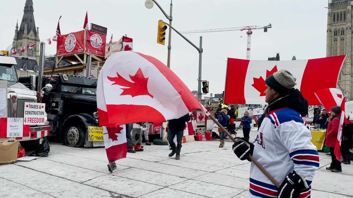 Man waves a Canadian flag on the 20th day of the Freedom Convoy in Ottawa.