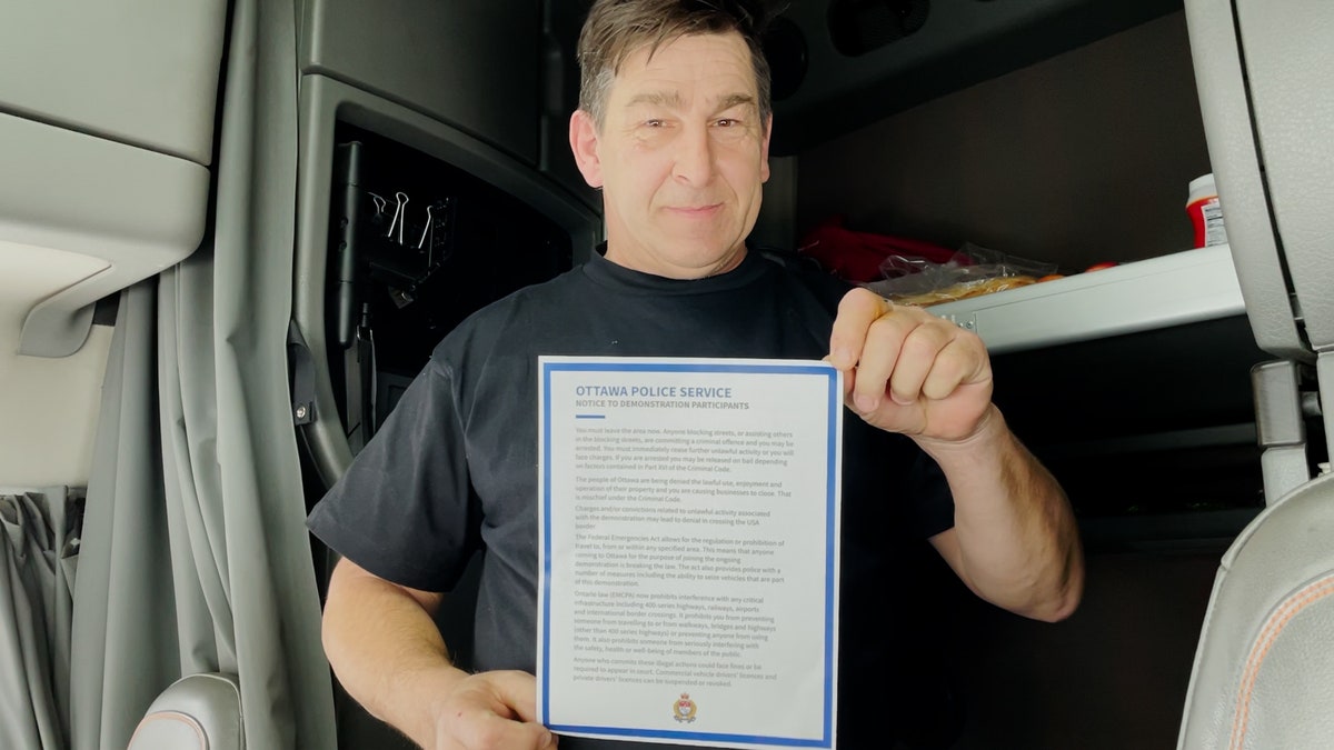 Trucker Mike Fabinski shows the police notice and says he is staying until the end.