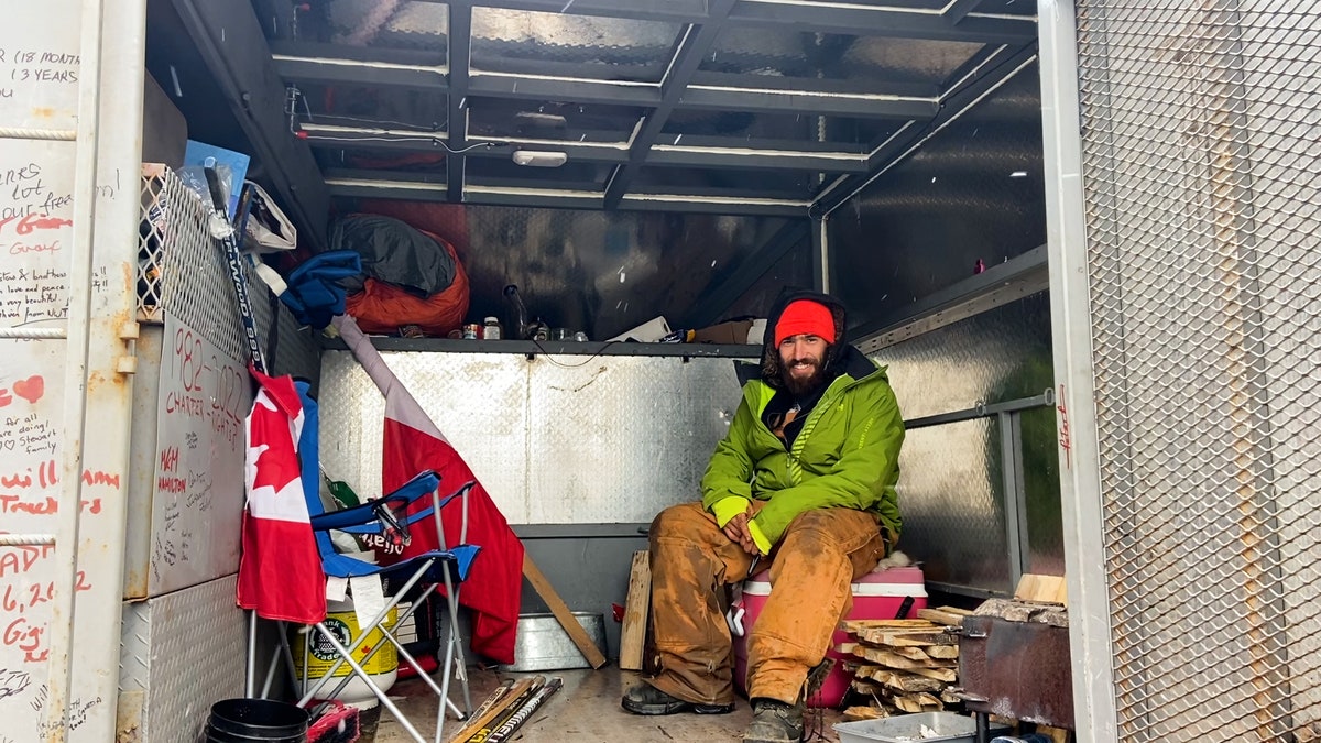 Inside the truck of a Canadian driver, Adrien de Medeiros, he sets up a hammock to sleep in at night