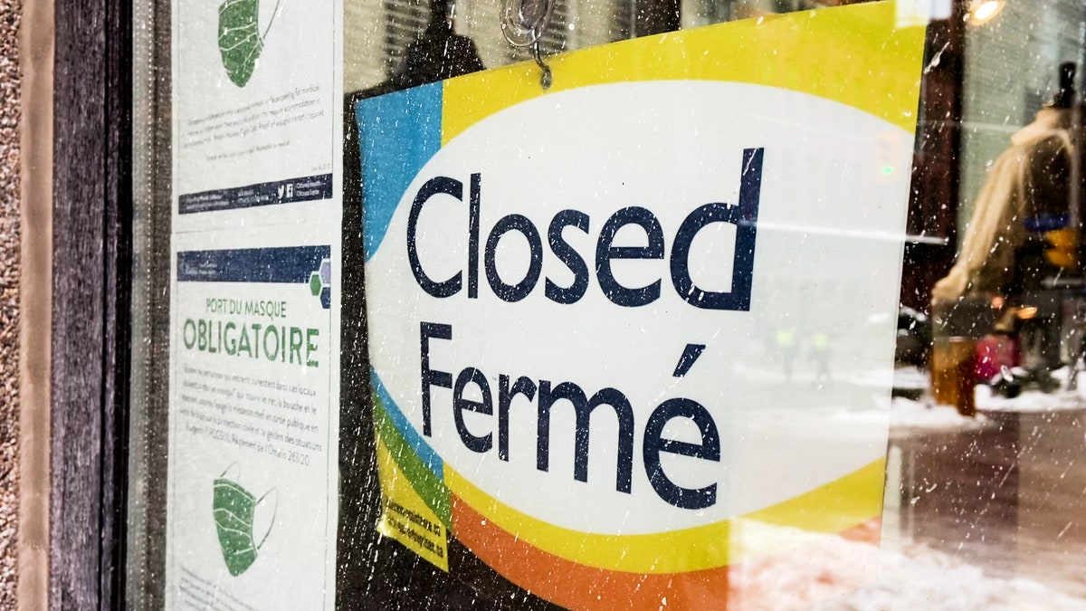 A "Closed" sign hangs on a business in downtown Ottawa