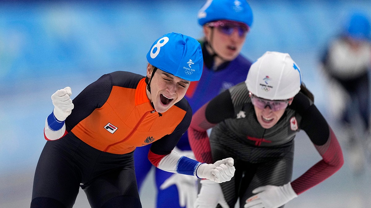 Irene Schouten of the Netherlands reacts after winning the gold medal ahead of silver medalist Ivanie Blondin of Canada, right, and Francesca Lollobrigida of Italy, behind, in the women's speedskating mass start finals at the 2022 Winter Olympics, Saturday, Feb. 19, 2022, in Beijing.