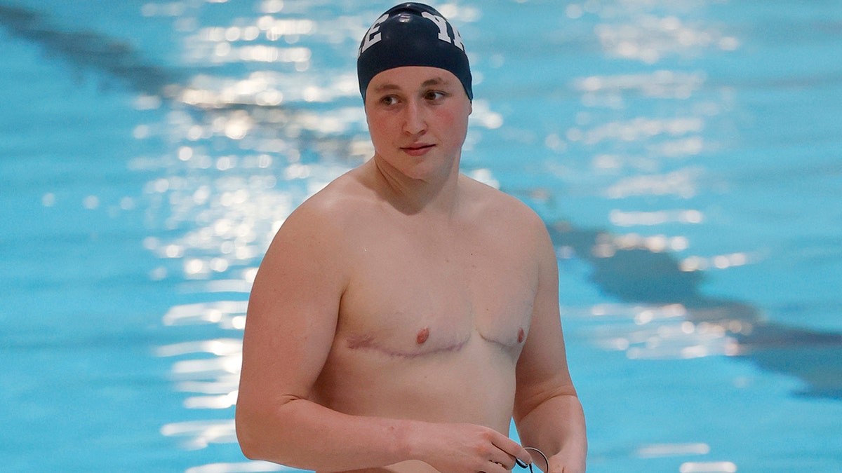 Yale's Iszac Henig stands on the pool deck before warming up for an event at the Ivy League Women's Swimming and Diving Championships at Harvard University, Thursday, Feb. 17, 2022, in Cambridge, Mass. Henig, who is transitioning to male but hasn't begun hormone treatments yet, is swimming for Yale's women's team.