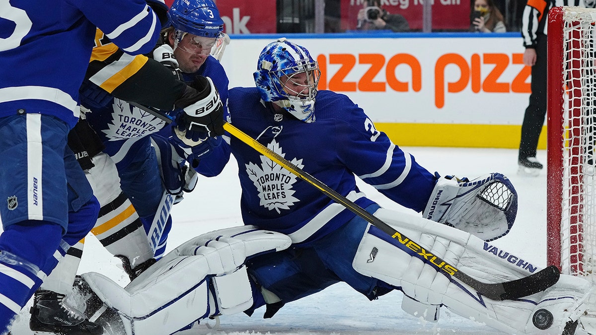 Toronto Maple Leafs goaltender Jack Campbell (36) makes a save on Pittsburgh Penguins forward Bryan Rust (17) as Maple Leafs defenseman Justin Holl (3) defends during the first period of an NHL hockey game Thursday, Feb. 17, 2022, in Toronto.