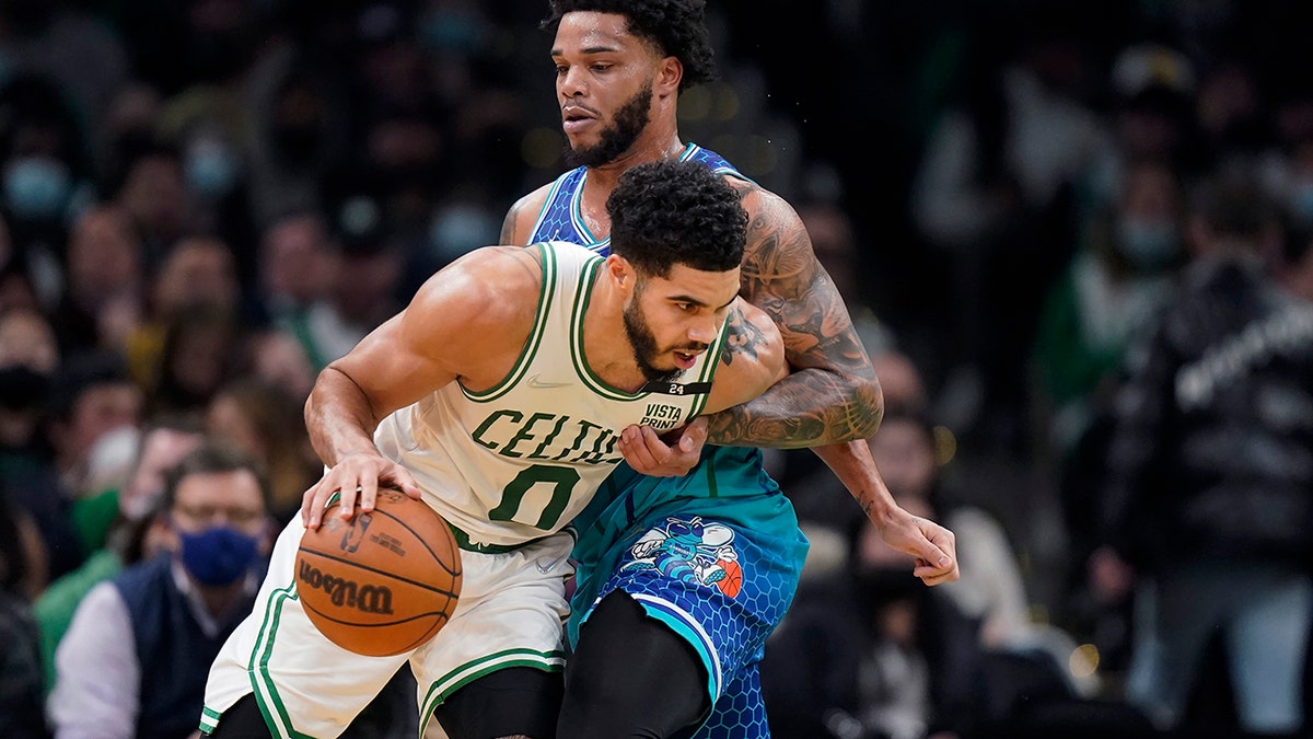 Boston Celtics forward Jayson Tatum (0) drives on Charlotte Hornets forward Miles Bridges during the second half of an NBA basketball game Wednesday, Feb. 2, 2022, in Boston.