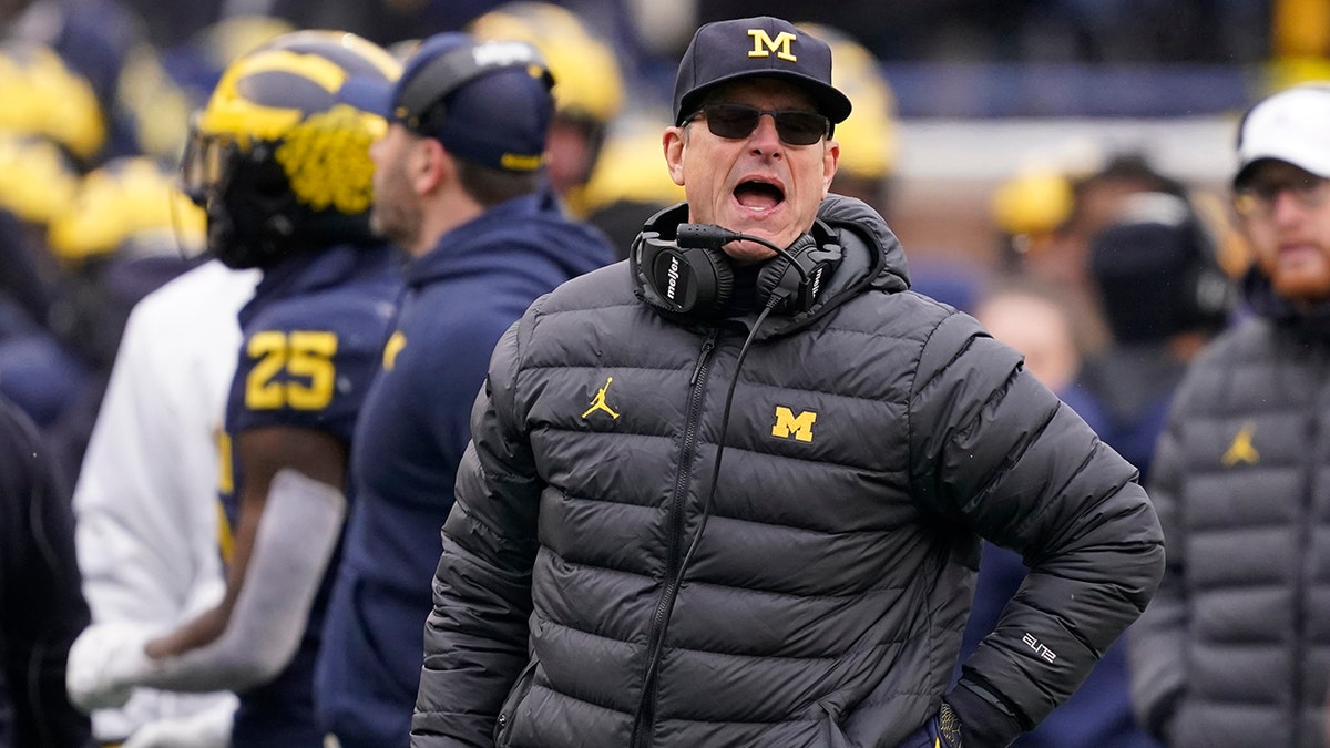 FILE -Michigan head coach Jim Harbaugh yells from the sideline during the second half of an NCAA college football game against Ohio State, Saturday, Nov. 27, 2021, in Ann Arbor, Mich. Michigan coach Jim Harbaugh has agreed to a reworked five-year contract with the school that runs through the 2026 season, Wednesday, Feb. 16, 2022.