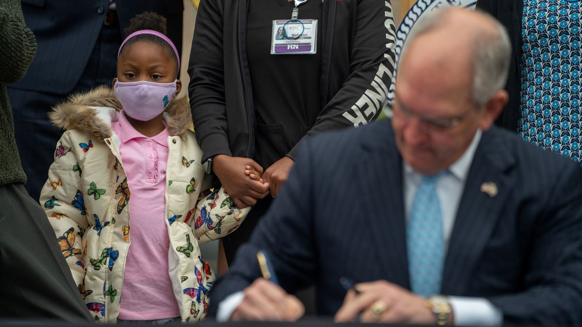 Louisiana Gov. John Bel Edwards signs pardon of Homer Plessy as onlookers watch