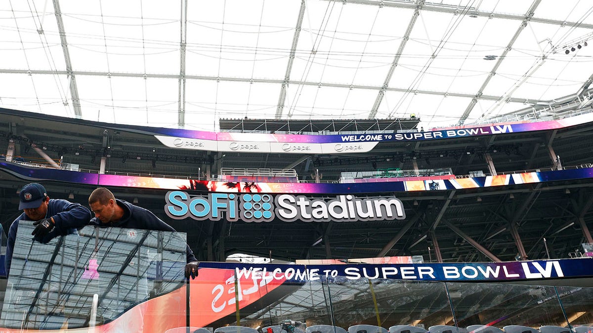 Workers install a glass partition in preparation for Super Bowl LVI at SoFi Stadium on Feb. 1, 2022 in Inglewood, California.