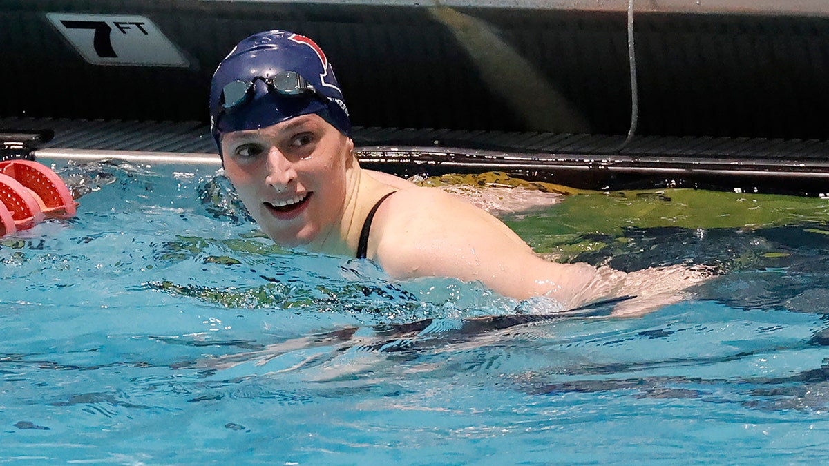 Lia Thomas smiling in the pool following 100-yard freestyl