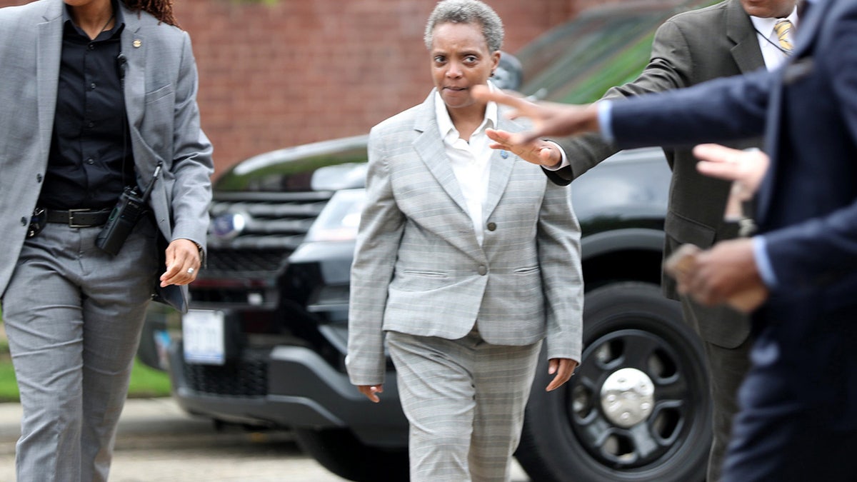 Chicago Police Officer Marni Washington, left, walks with Mayor-elect Lori Lightfoot on Sunday, May 19, 2019, at Resurrected Life Church International. 