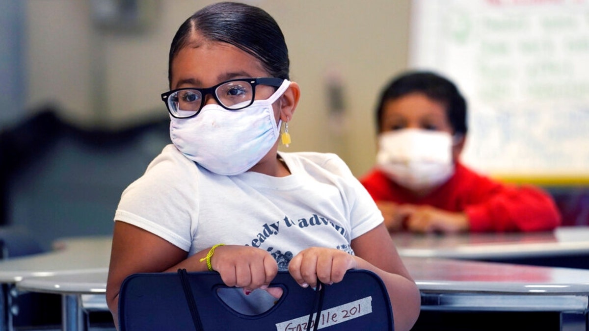 A summer school student wears a protective mask, due to concerns of the COVID-19 virus pandemic, while listening to instruction at the E.N. White School in Holyoke, Massaschusetts, on Wednesday, Aug. 4, 2021. 